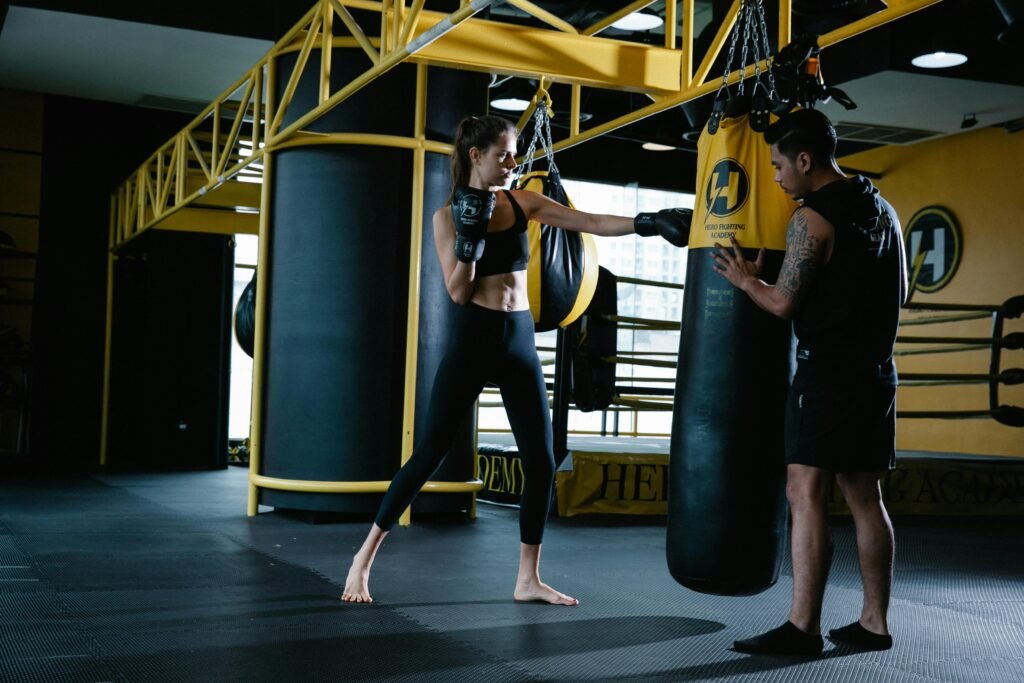 Two boxers training on heavy bags in a gym